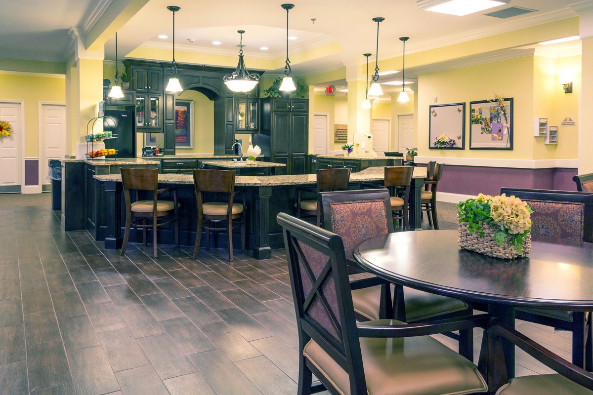 A modern kitchen and dining area with bar stools and pendant lighting.