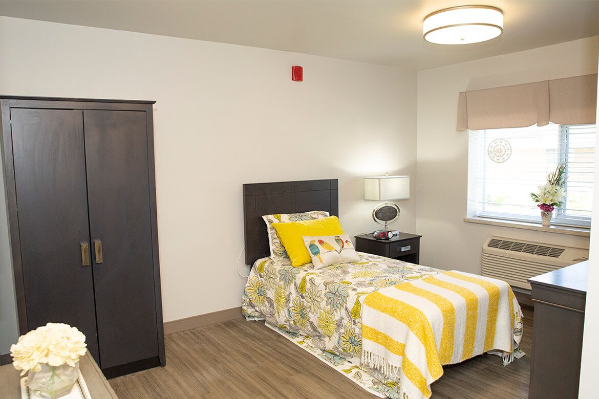 A cozy bedroom with a single bed and bright yellow accents.