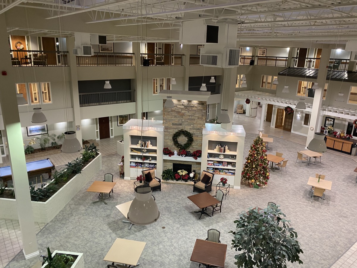 A spacious atrium with festive decorations, including a Christmas tree and seating areas.