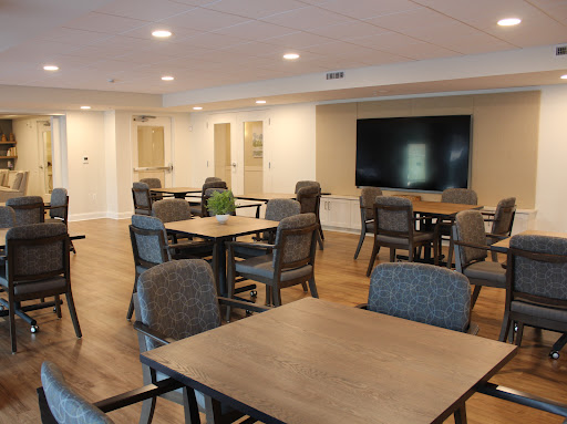 A modern dining and meeting area featuring wooden tables and comfortable chairs, designed for community gatherings.