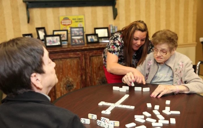 A group of people playing dominoes together indoors.