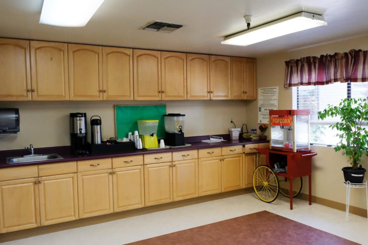 Spacious kitchen area with cabinets, a popcorn machine, and coffee station.