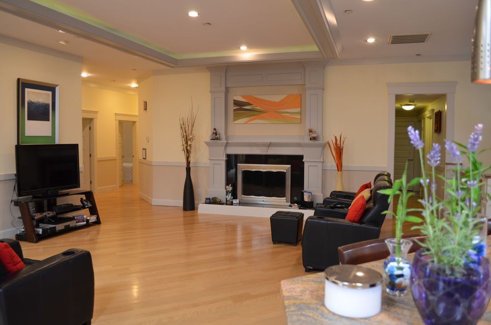 A modern living room featuring a central fireplace, hardwood floors, and contemporary decor.