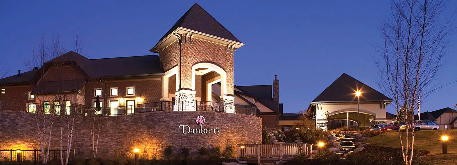 A beautifully lit brick building stands out against the evening sky, showcasing elegant architectural design.