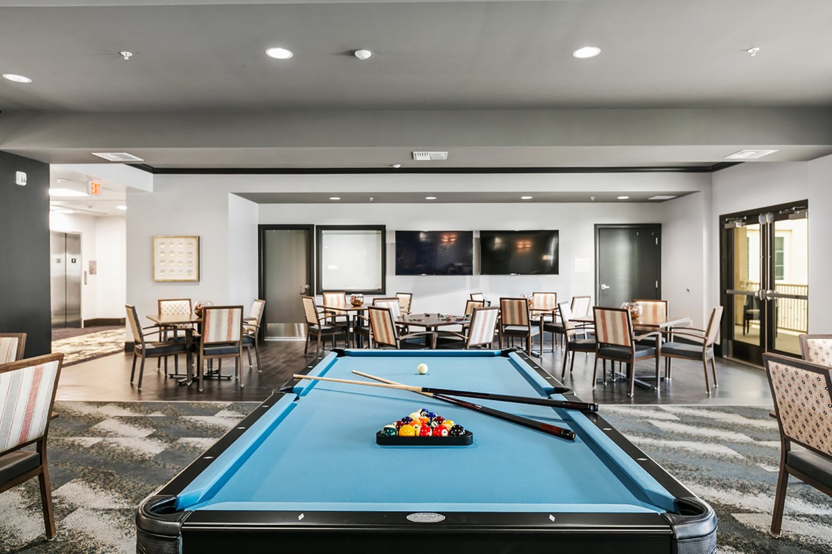 A modern game room featuring a billiards table and seating area.