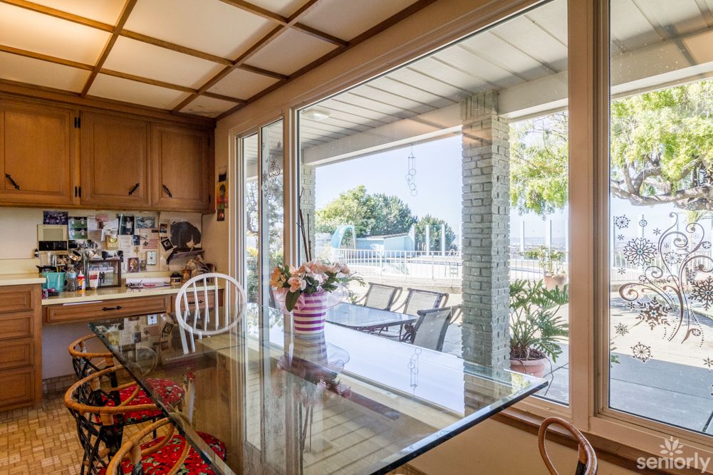 A cozy kitchen with a dining area overlooking the outdoor patio through large windows.