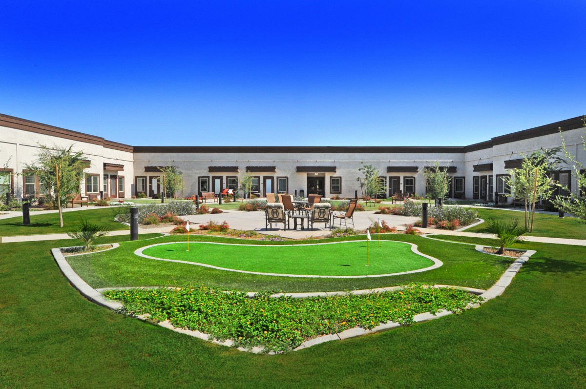 A well-maintained courtyard featuring a green lawn and modern landscaping.