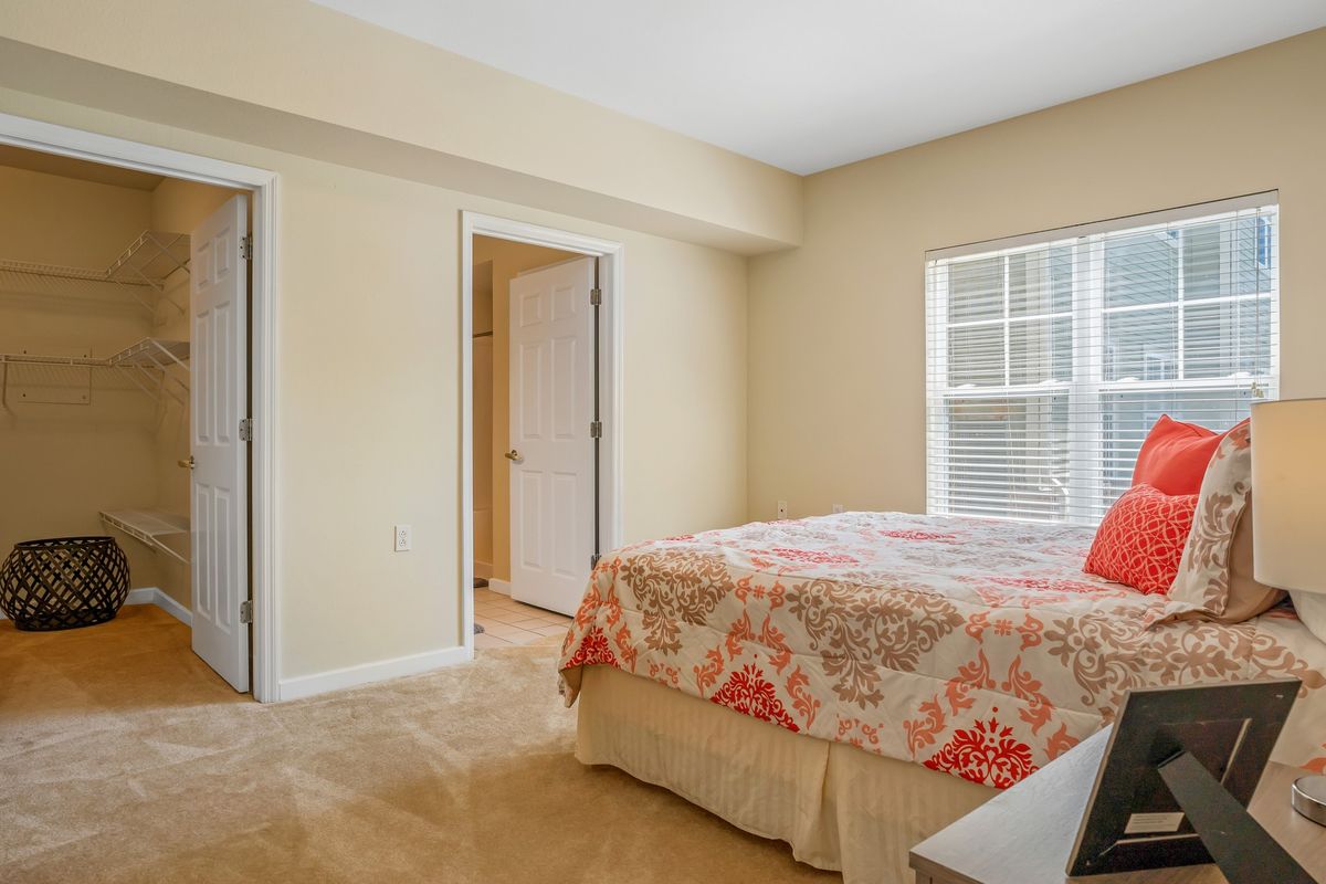 A cozy bedroom with a neatly made bed and light-colored walls.