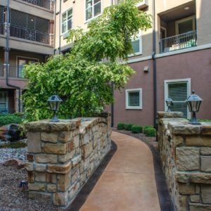 A well-maintained courtyard with a stone-lined pathway surrounded by an apartment building.