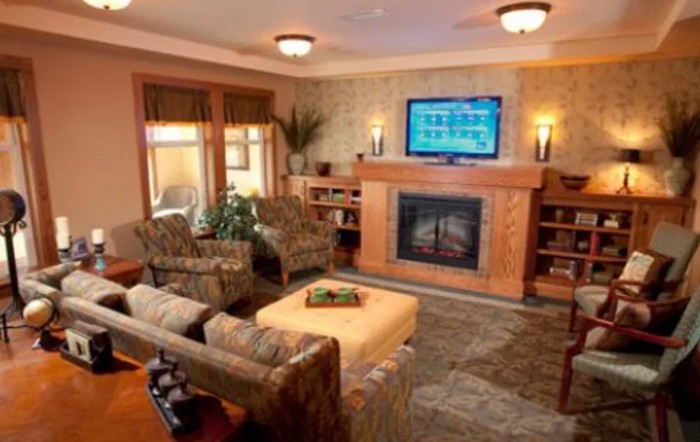 A cozy living room featuring a fireplace and television, surrounded by comfortable seating and modern decor.