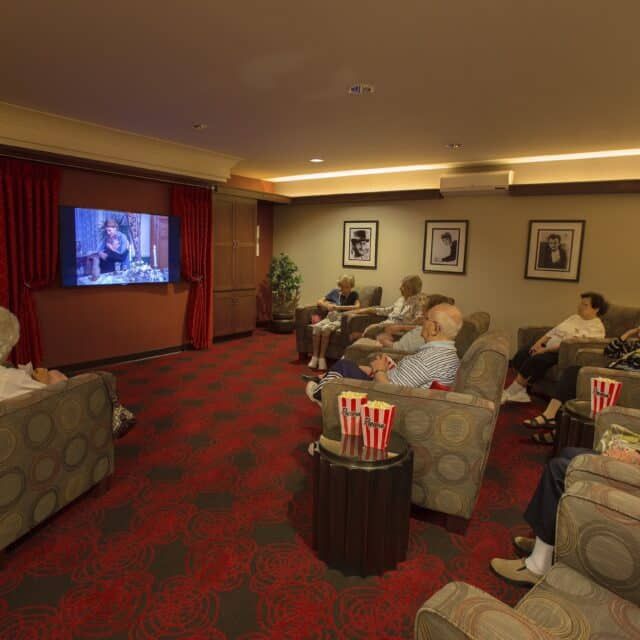 A group of people enjoying a movie night in a cozy home theater setup.
