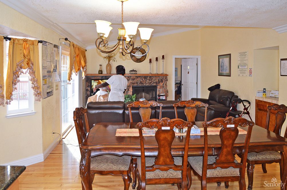 A cozy interior featuring a dining and living area with a wooden dining set and a chandelier.