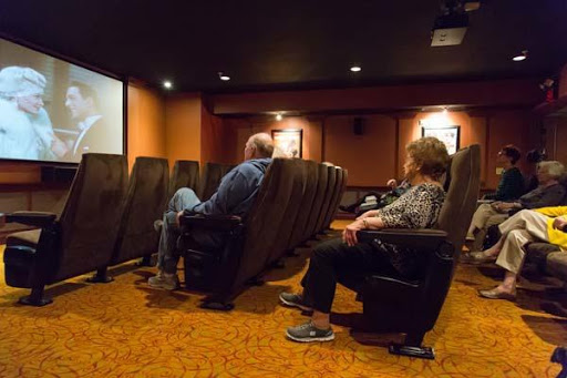 A cozy home theater setup with two individuals enjoying a movie.