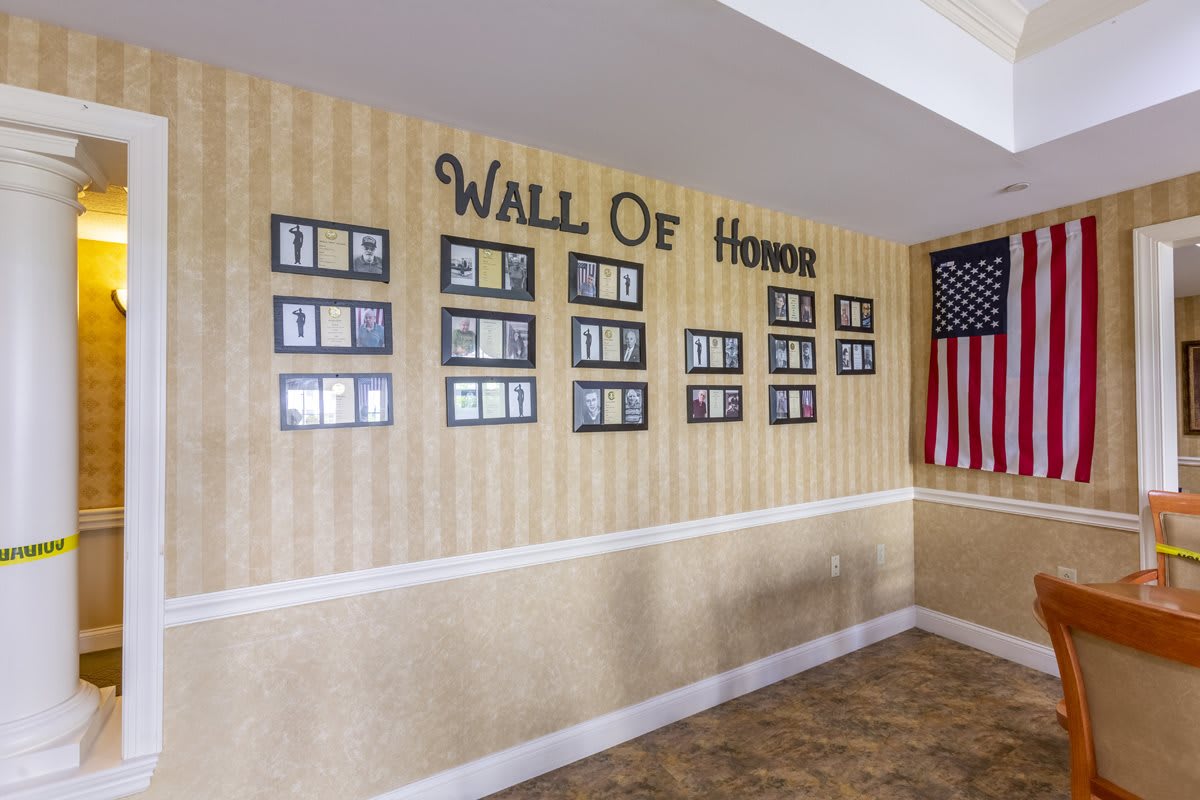 A Wall of Honor displaying photographs and a tribute to veterans, accompanied by an American flag.
