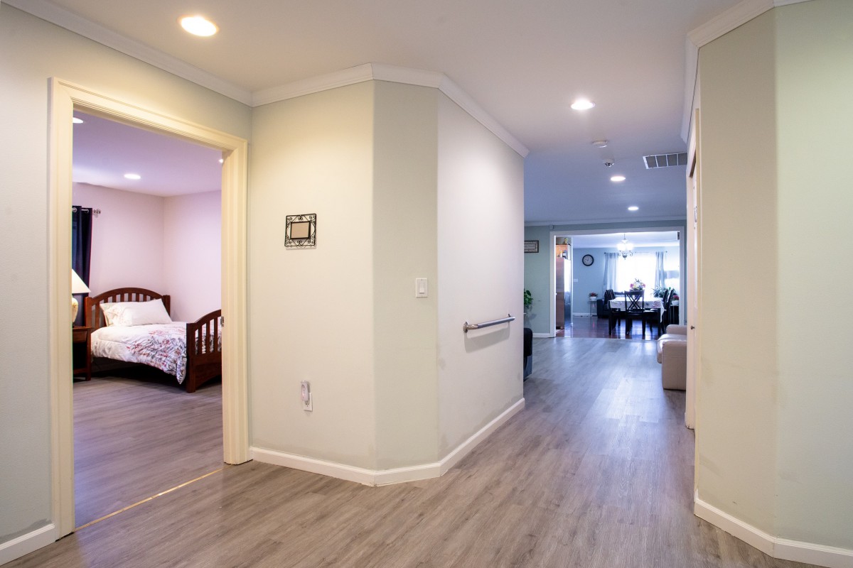 A modern home interior featuring a hallway leading to a bedroom and living area.