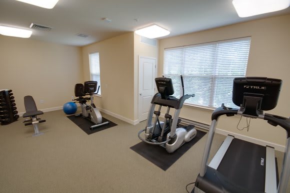 A compact gym space with treadmills and elliptical machines for exercise.