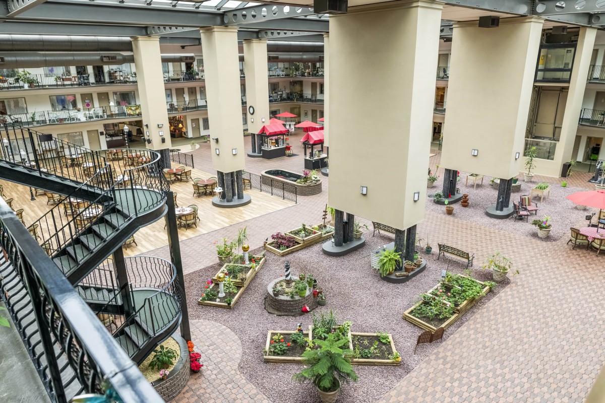 A spacious indoor atrium featuring plants and modern architectural design.