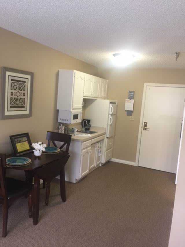 A compact kitchenette with a small dining area in an apartment.