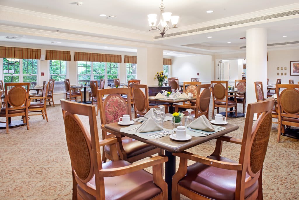 An elegantly set dining room with neatly arranged tables and chairs, ready for guests.