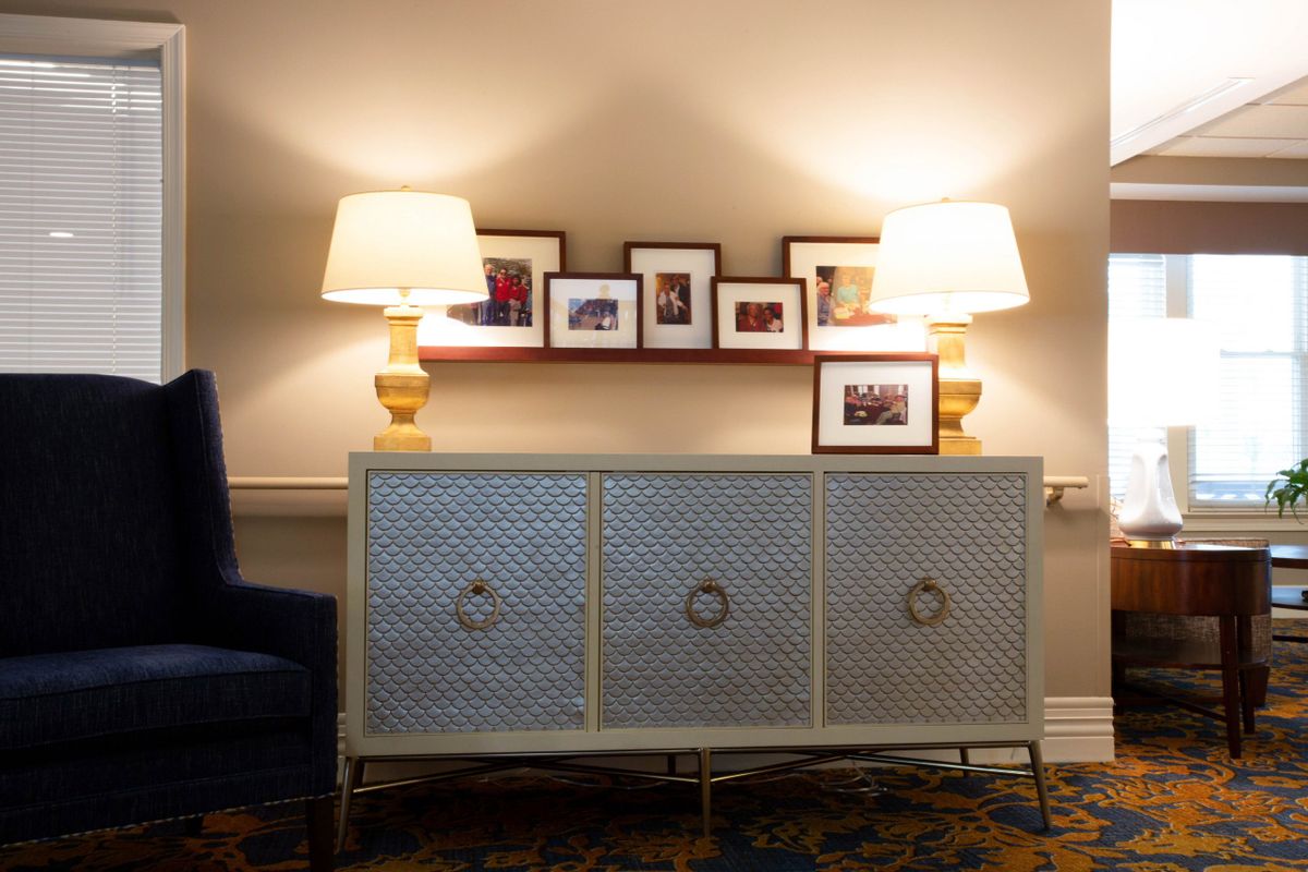 A stylish sideboard with decorative lamps and framed pictures, enhancing a cozy ambiance.