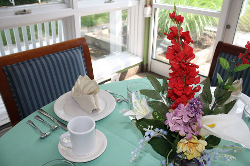 A beautifully arranged dining table featuring elegant flowers and a neatly folded napkin.