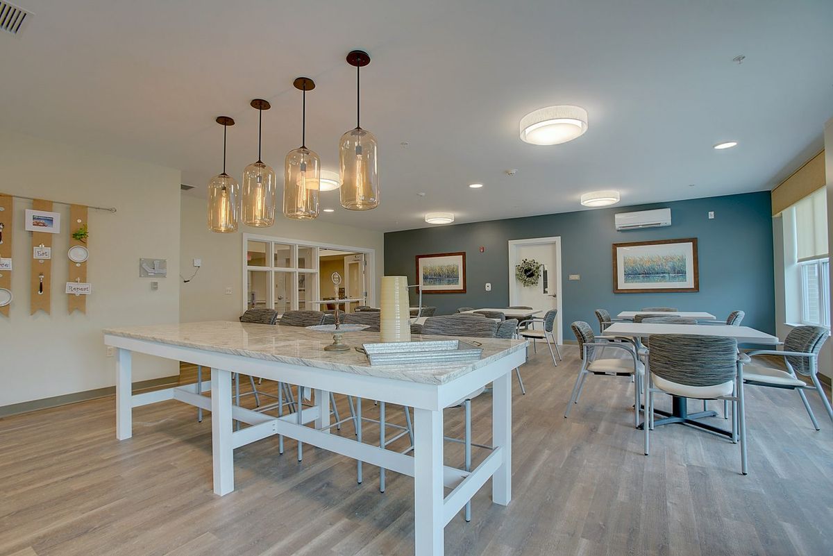 A modern kitchen and dining area with pendant lighting and a blue accent wall.