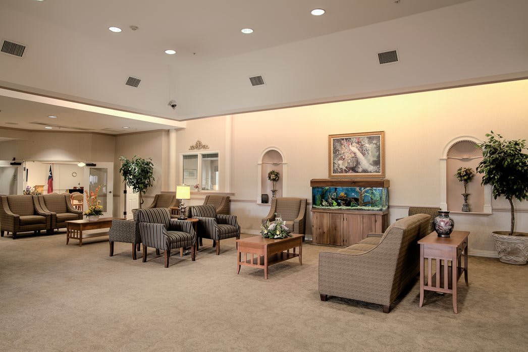 A comfortable waiting area with armchairs, a fish tank, and elegant interior decor.