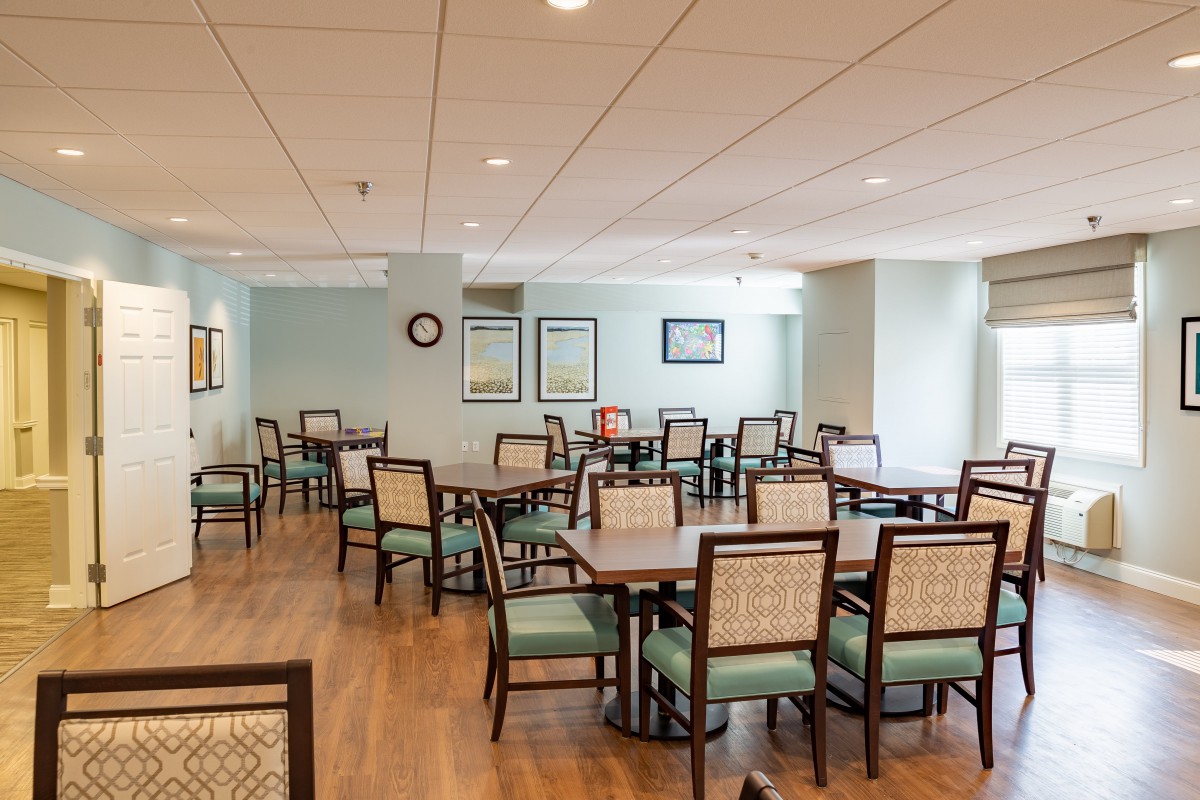 An empty dining room with neatly arranged tables and chairs.