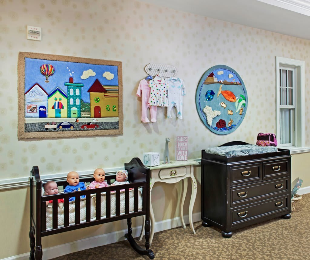 A cozy nursery with a crib, changing table, and colorful wall decorations.