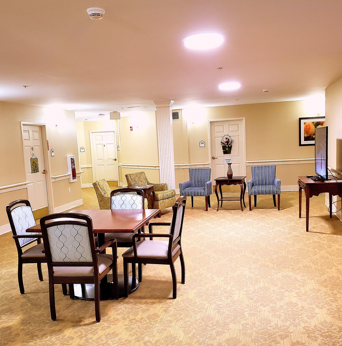 A cozy lounge area with tables and chairs, well-lit with warm lighting.