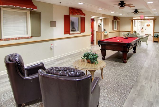 A cozy indoor game room featuring a pool table and comfortable seating area.