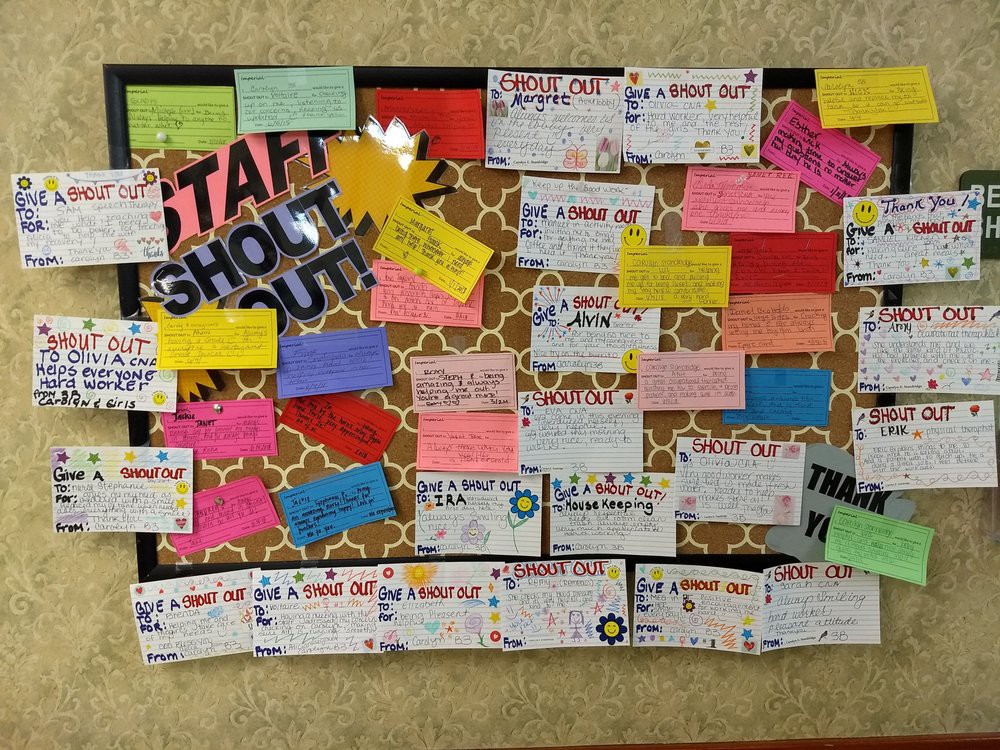 A bulletin board filled with colorful staff shoutouts and appreciation notes.