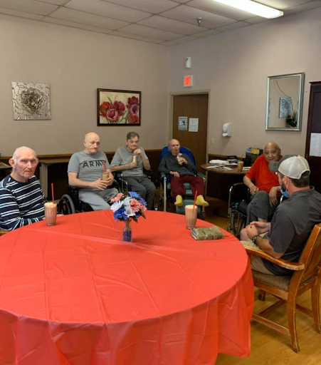 Residents of a senior community engage in a group activity in a cozy indoor setting.