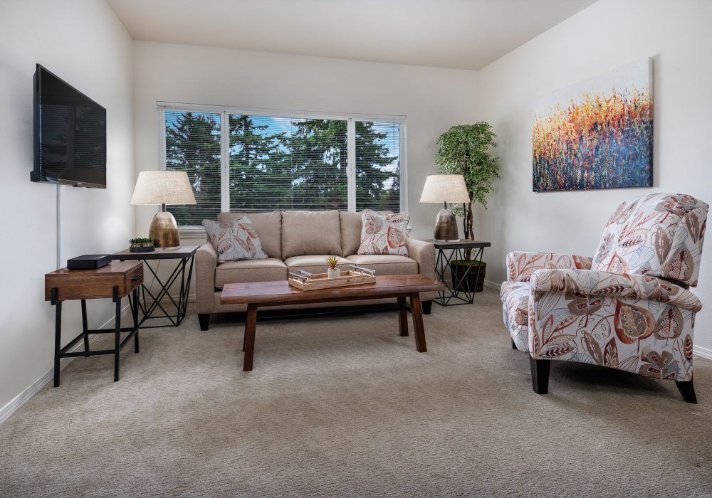 A cozy living room with a sofa, armchair, coffee table, and decorative elements.