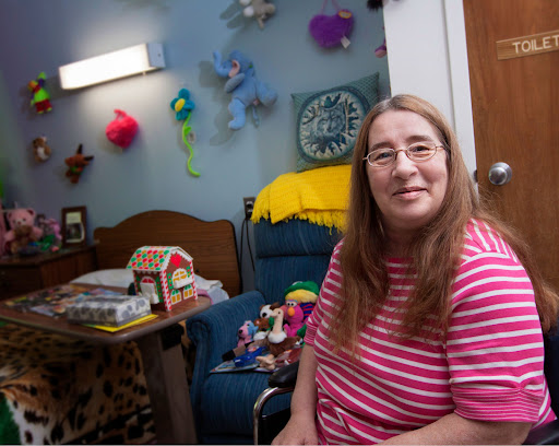 A warm and inviting room where a smiling person sits comfortably, surrounded by colorful decorations.