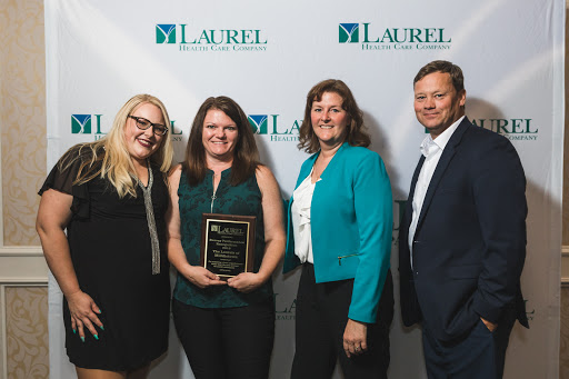 A group of professionals celebrating an award recognition at the Laurel event.