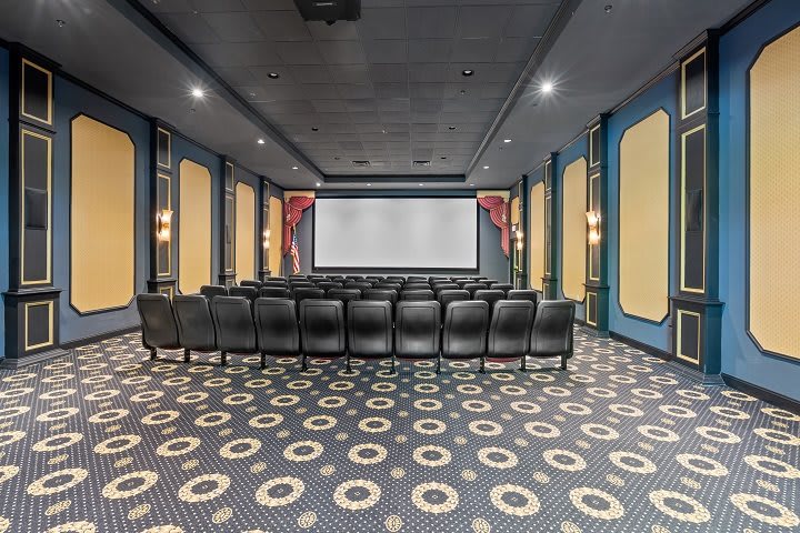 A luxurious home theater with comfortable seating and a large screen.