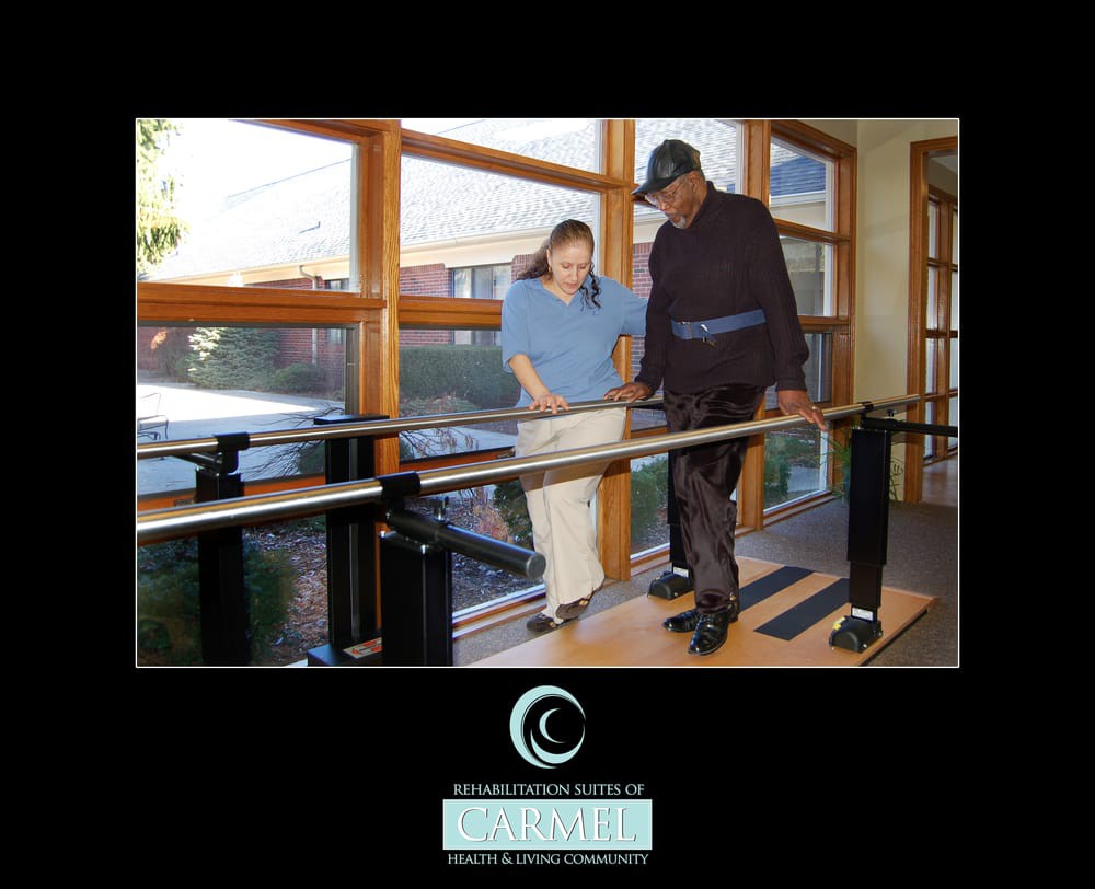 A person receiving assistance on balance bars during a physical therapy session.