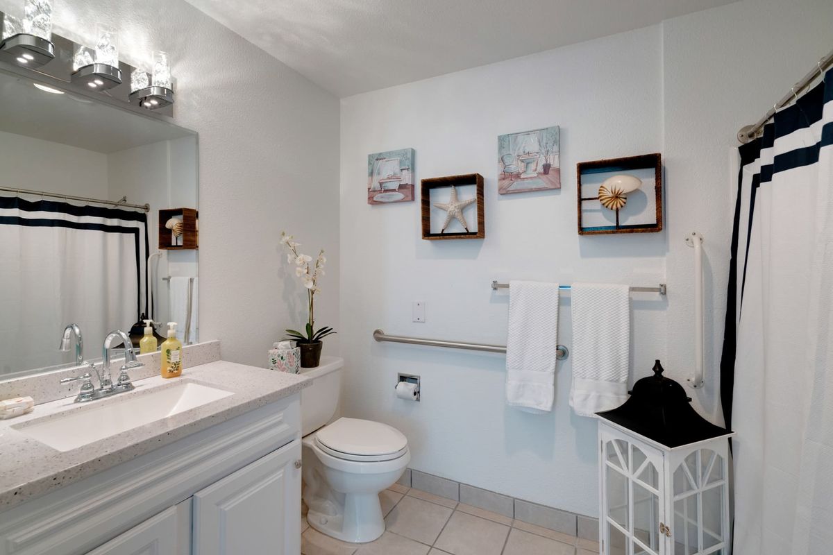 A modern bathroom with decorative artwork and neatly arranged towels.