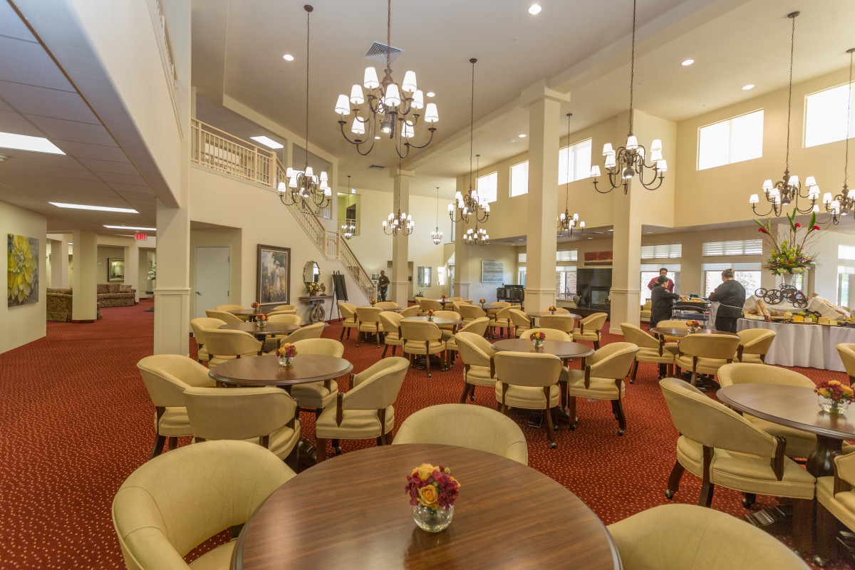 A spacious dining area with elegant chandeliers and comfortable seating arrangements.