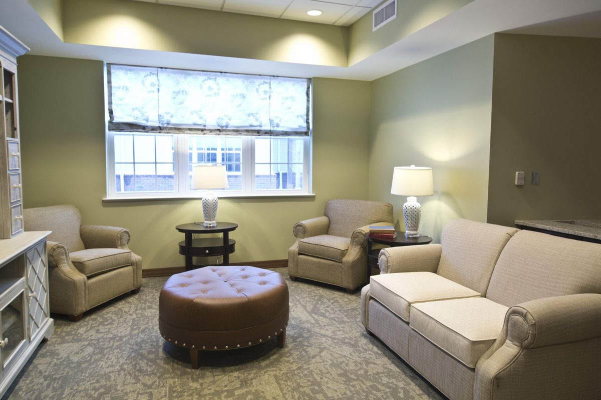 A cozy living room with a sofa, two armchairs, and a round coffee table.