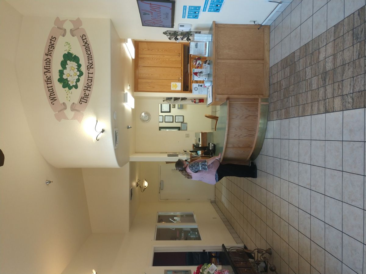 A hotel lobby with a reception desk and decorative wall art.