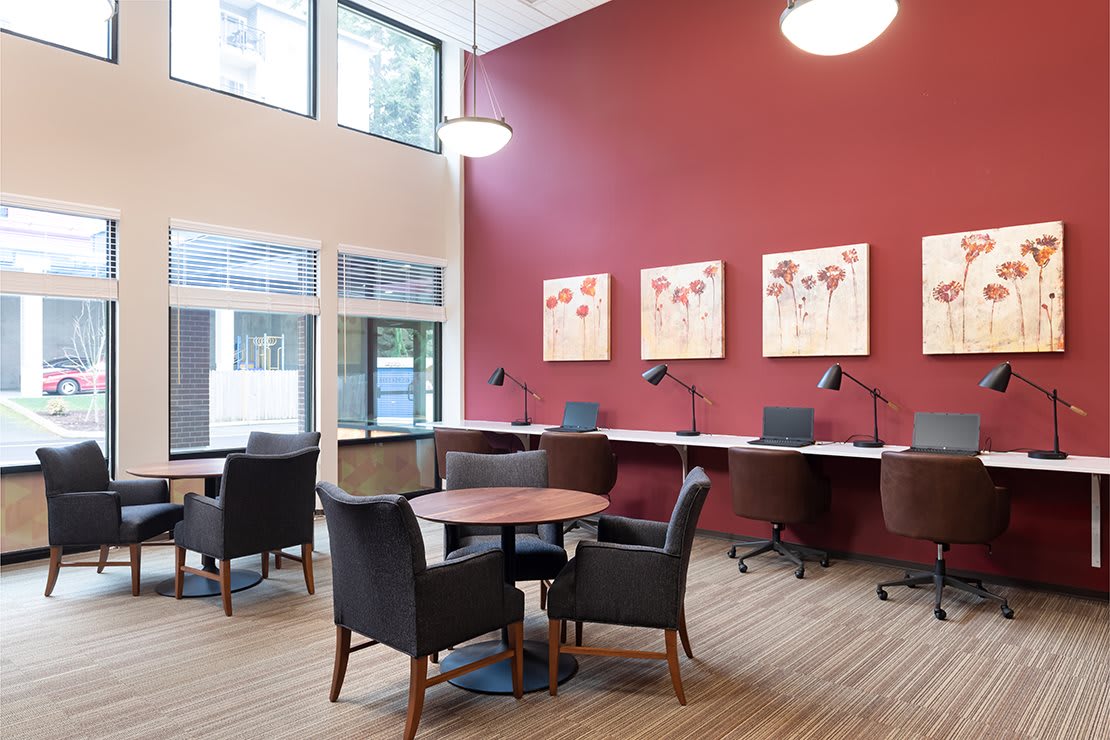 A modern office space with comfortable seating, tables, and wall art.