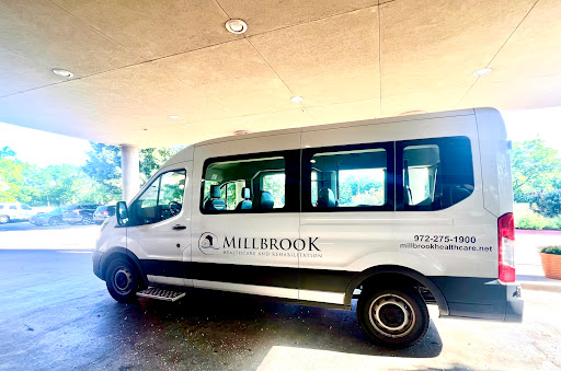 A white Millerbrook van parked in a covered area.