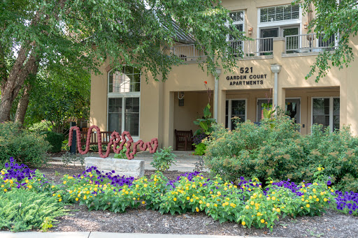 The welcoming entrance of a beautifully landscaped apartment complex.