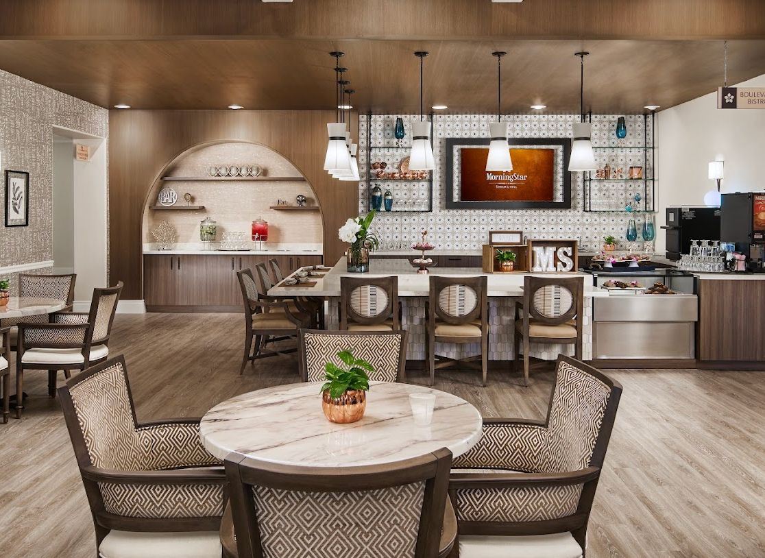 A modern and stylish kitchen area with seating and decorative lighting.
