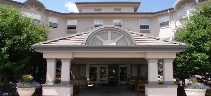 An entrance to a multi-story building with large windows and a covered entryway.