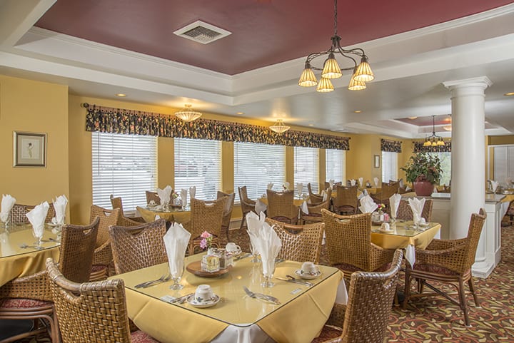 An elegant restaurant dining area with neatly arranged tables and chairs, featuring upscale decor and ambient lighting.
