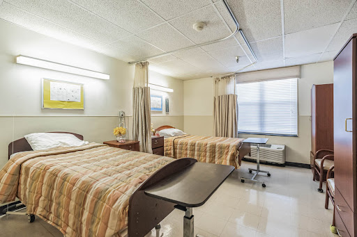 A well-lit hospital patient room featuring two beds and a modern design.