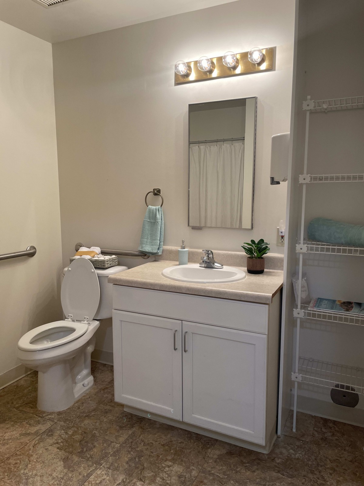 A well-organized bathroom with a toilet, sink, and mirror.